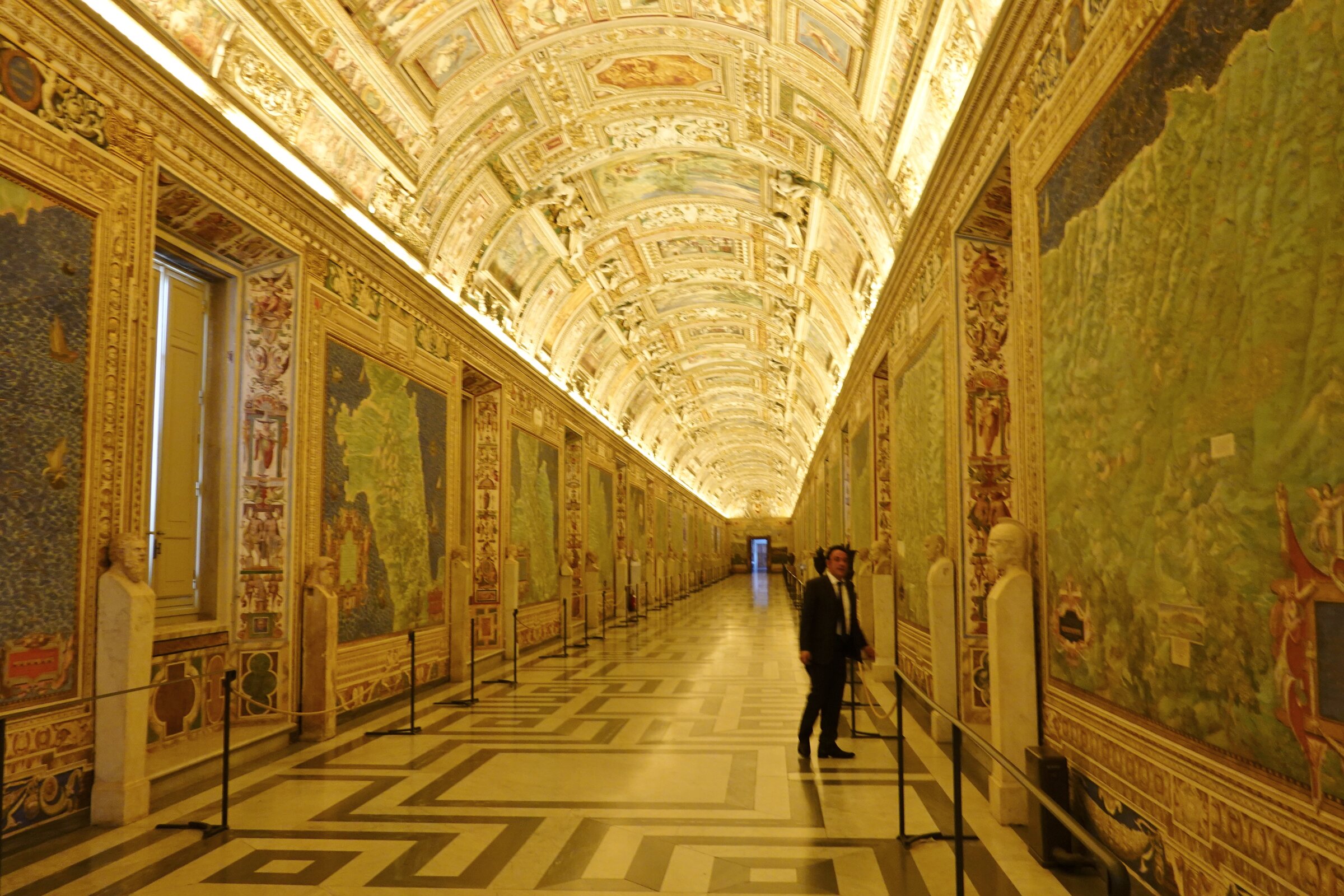 Panoramic view of the Gallery of Geographical Maps in the Vatican Museums, with frescoed regional maps on the walls and the gilded vaulted ceiling above