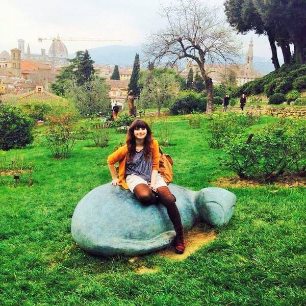 Visitor seated beside a bronze figure by Jean-Michel Folon in the Rose Garden, Florence