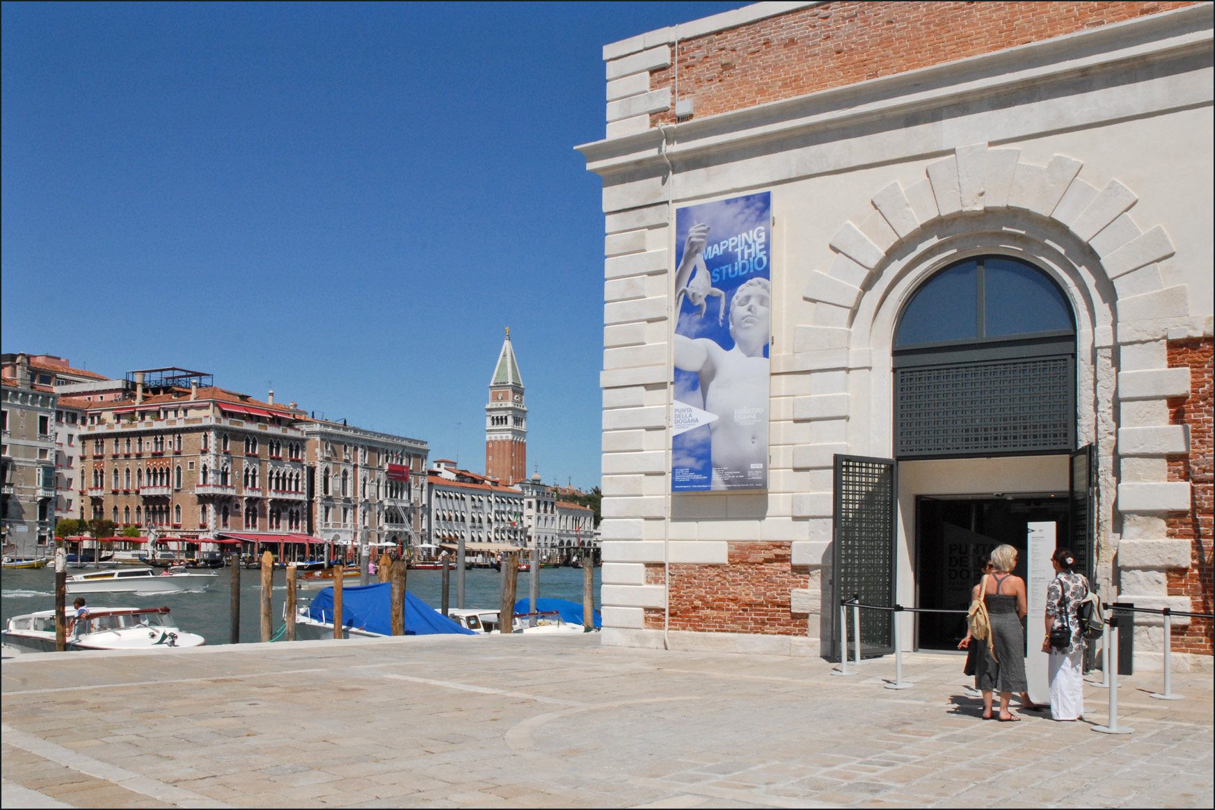 The tip of Punta della Dogana at dusk during the June 2009 opening of the Pinault Foundation museum, with the gilded globe and Fortuna statue visible above the cornice