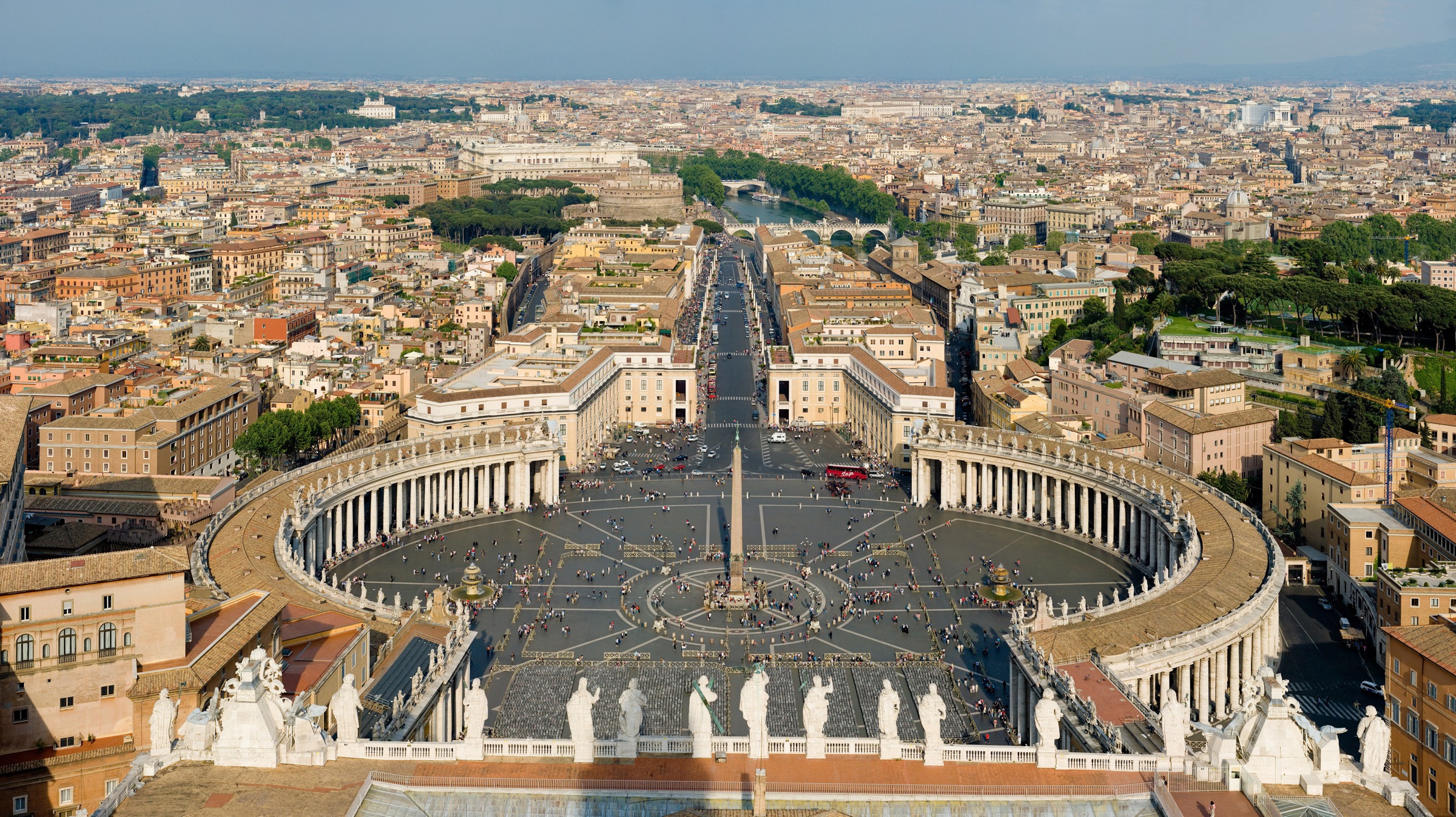 St. Peter's Square seen from the dome of the basilica, with Bernini's elliptical colonnade enclosing the obelisk and twin fountains, Via della Conciliazione extending east toward Rome