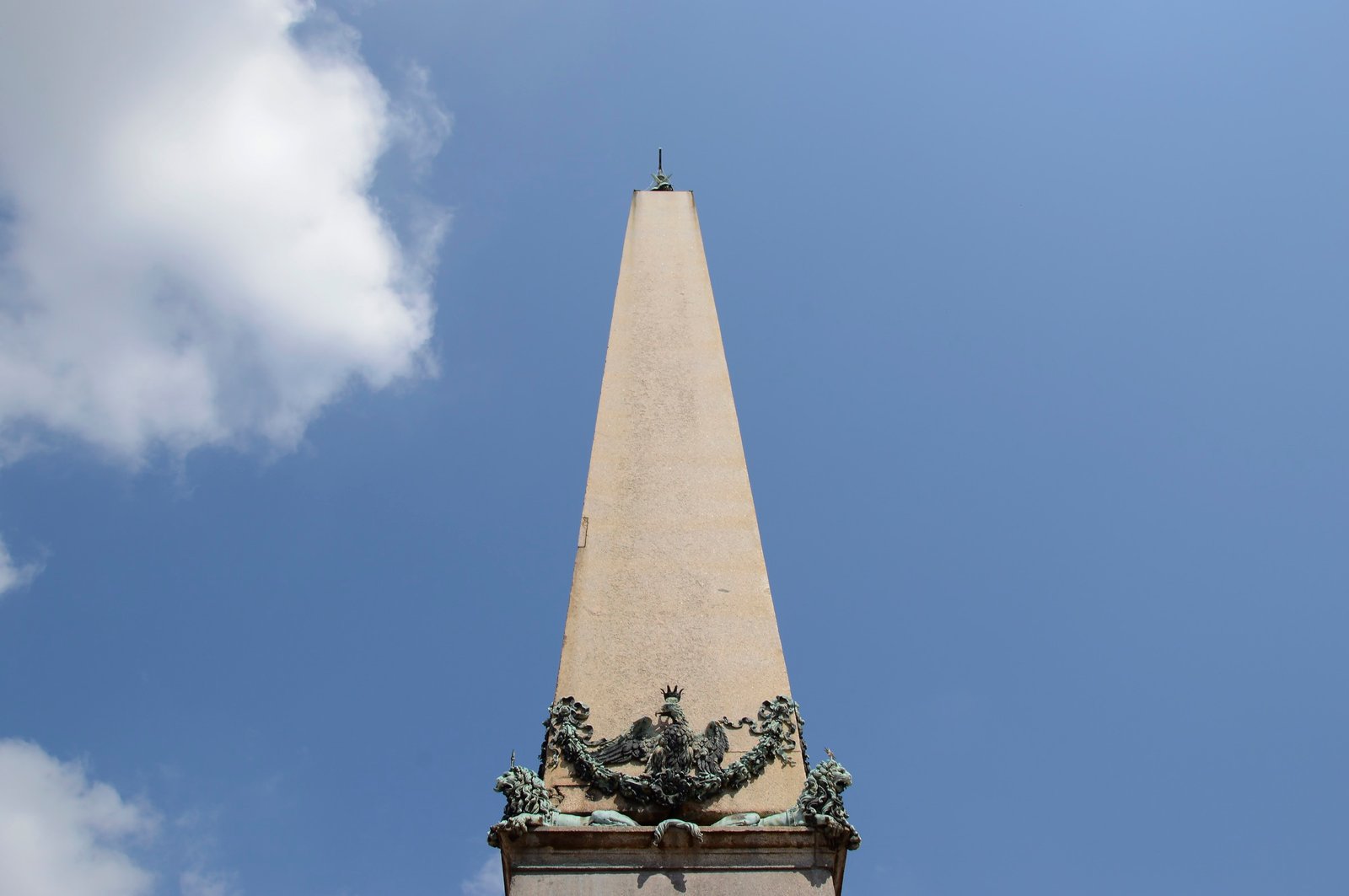 The Vatican Obelisk in red granite, uninscribed, topped by a metal cross, standing at the centre of St. Peter's Square