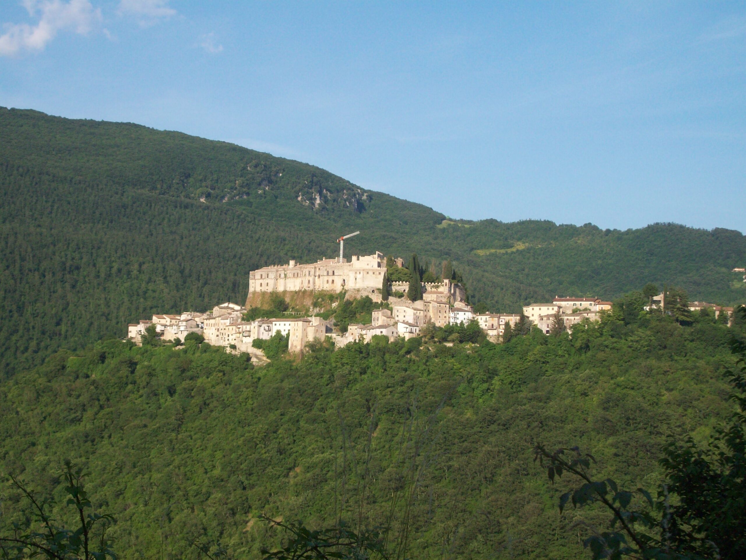 Castello di Rocca Sinibalda seen from above, its mass spreading over the rocky spur in the Sabina hills