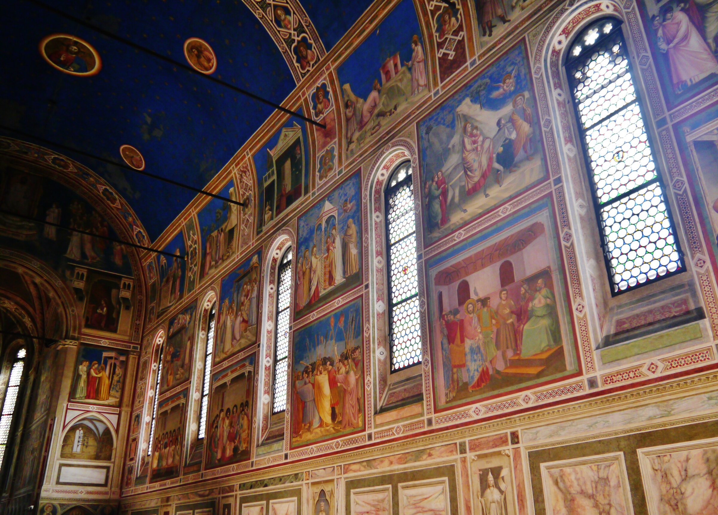 Interior of the Scrovegni Chapel in Padua, with Giotto's frescoes covering the nave walls and the lapis-lazuli starry vault overhead