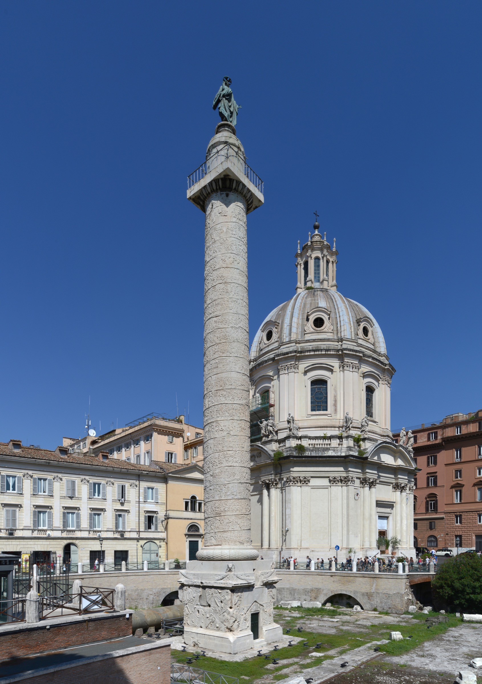 Full view of Trajan's Column rising above the Foro di Traiano in Rome, with the bronze statue of Saint Peter at its summit