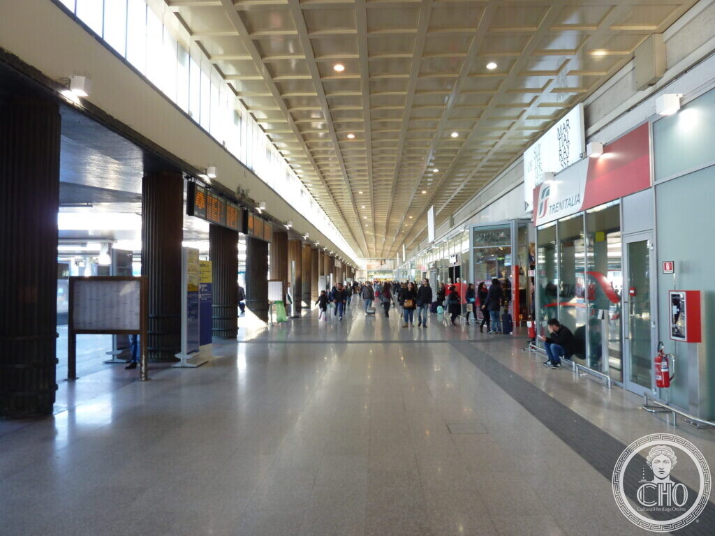 The long interior concourse of Venice Santa Lucia station with a coffered ceiling, departure boards and travellers