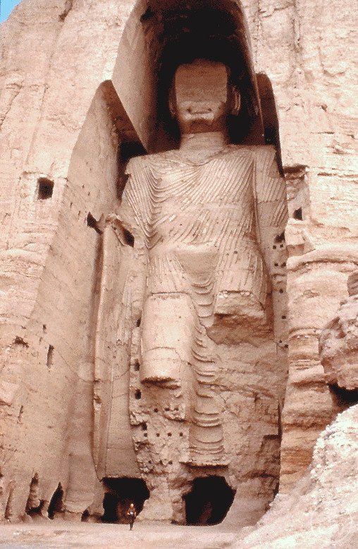 The larger Buddha of Bamiyan standing in its niche carved into the sandstone cliff, photographed before the 2001 destruction