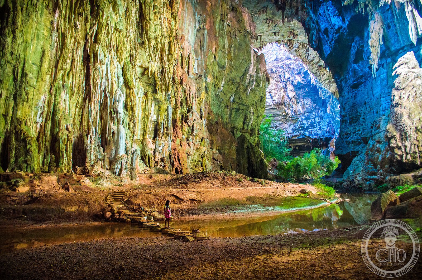 Xakriabá indigenous child inside the vast Janelão cave chamber in Cavernas do Peruaçu National Park, Minas Gerais, Brazil — a cave with prehistoric rock paintings and enormous speleothems