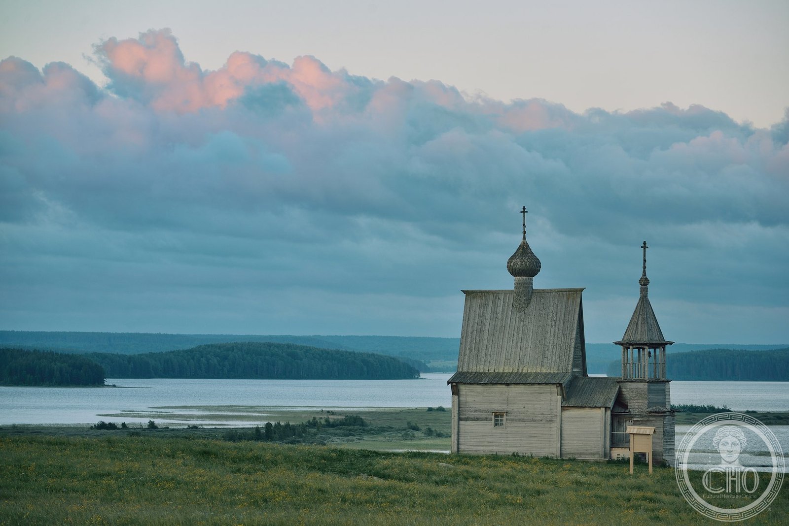 Traditional Russian wooden village of Vershirino reflected in Lake Kenozero at evening, Arkhangelsk Oblast, Russia