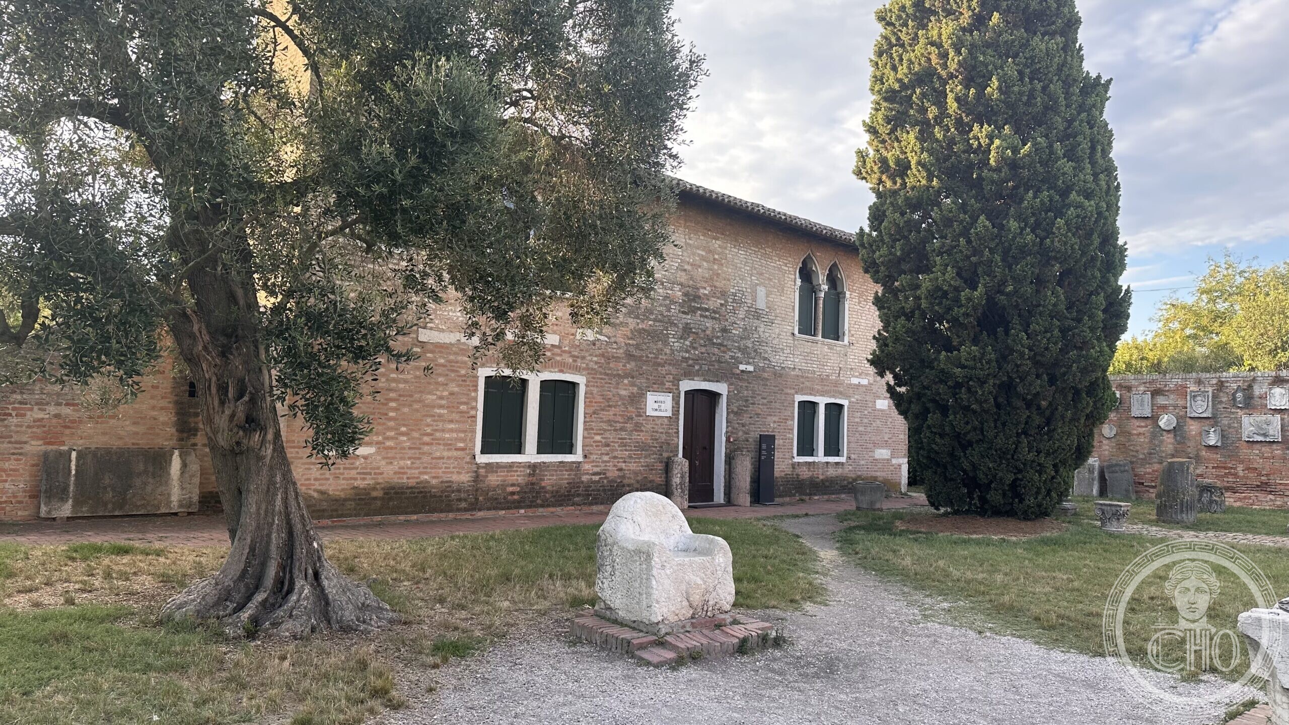 The Museo di Torcello building with the stone armchair known as the Trono di Attila in front of it