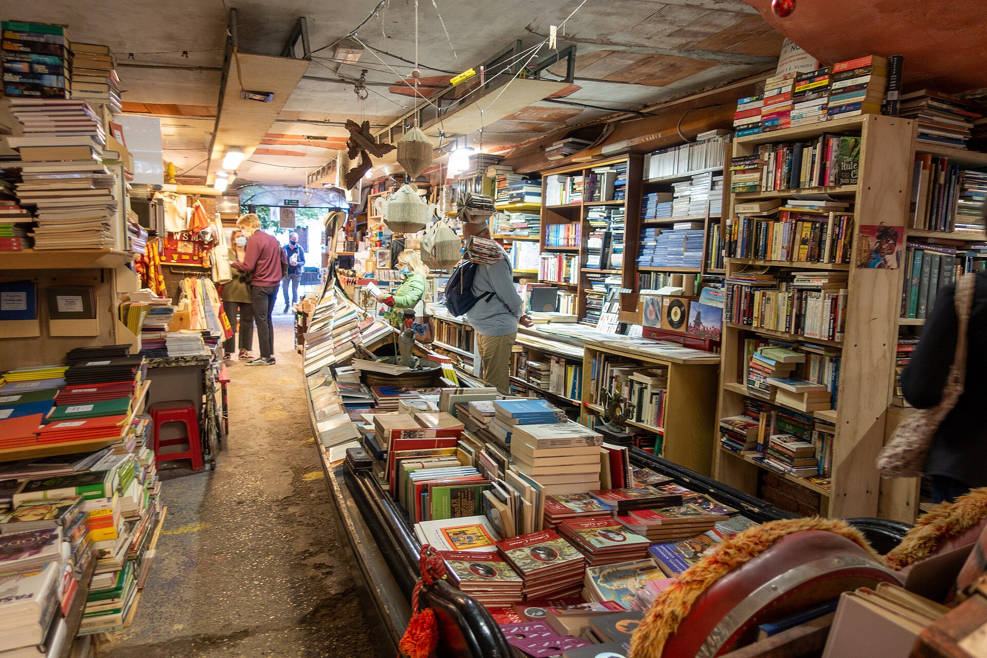 Inside the shop, where a full-size gondola holds the stock and the aisles are walled with books.