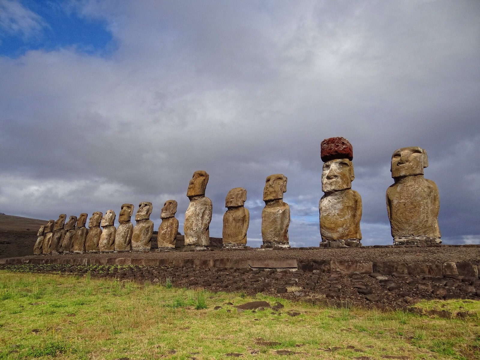 Ahu Tongariki moai statues on Easter Island silhouetted against a vivid sunrise sky, seen from a drone perspective