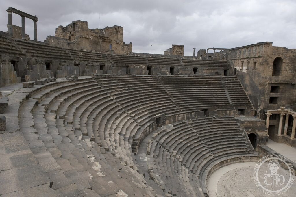 The vast semicircle of black basalt seating of the Roman theatre at Bosra