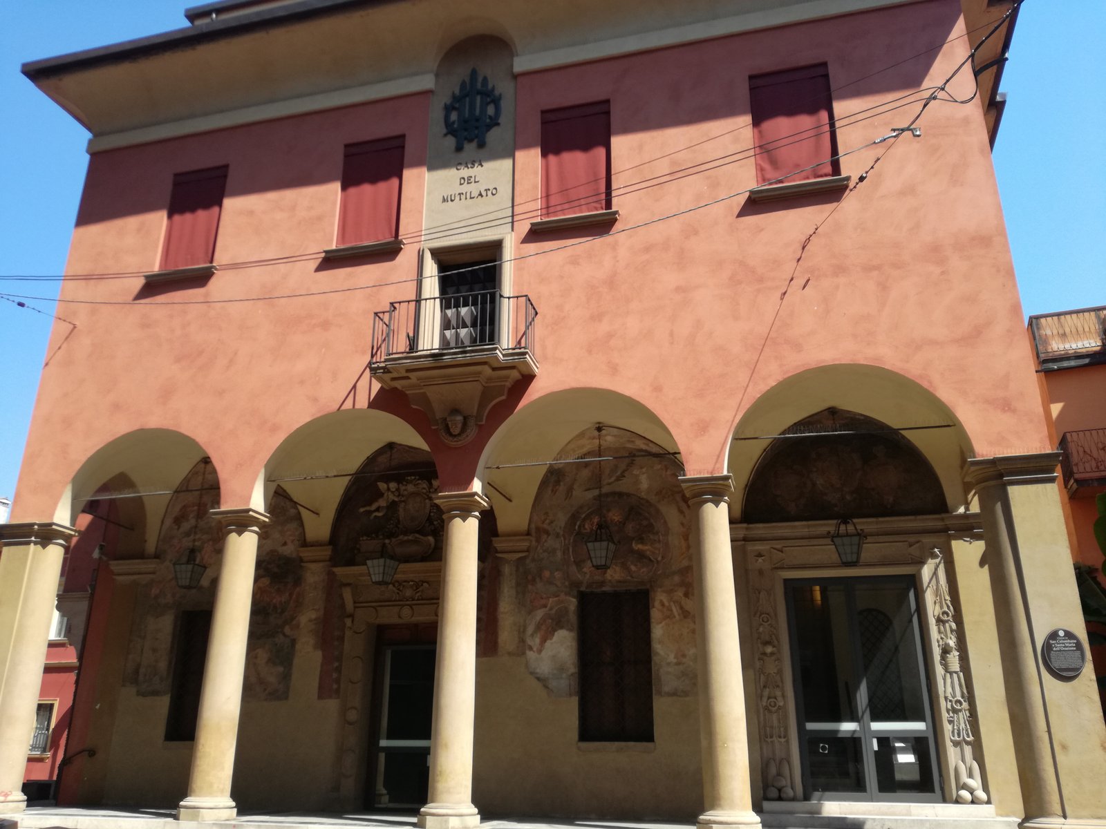 The portico of the Casa del Mutilato on Via Parigi in Bologna, with brick piers and the entrance to the war veterans headquarters