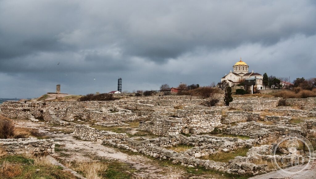 The seaside ruins of the ancient Greek city of Tauric Chersonese with a domed cathedral behind