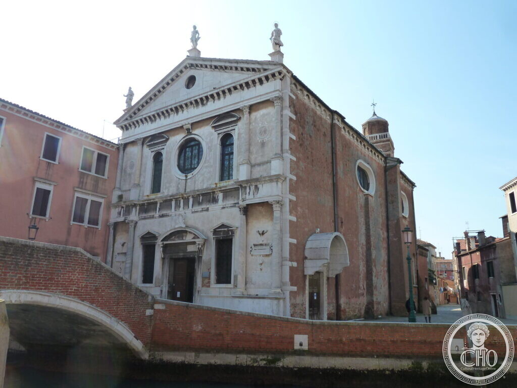 The church of San Sebastiano seen at an angle, its white facade and long brick side wall, a bell tower rising behind