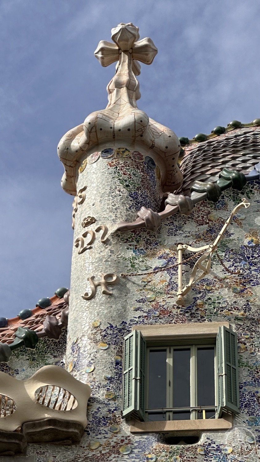Casa Batlló — The dragon-back roof and the turret crowned with a cross.