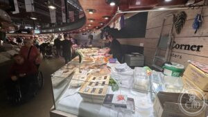 La Boqueria — Cheese and packaged goods at a market stall.