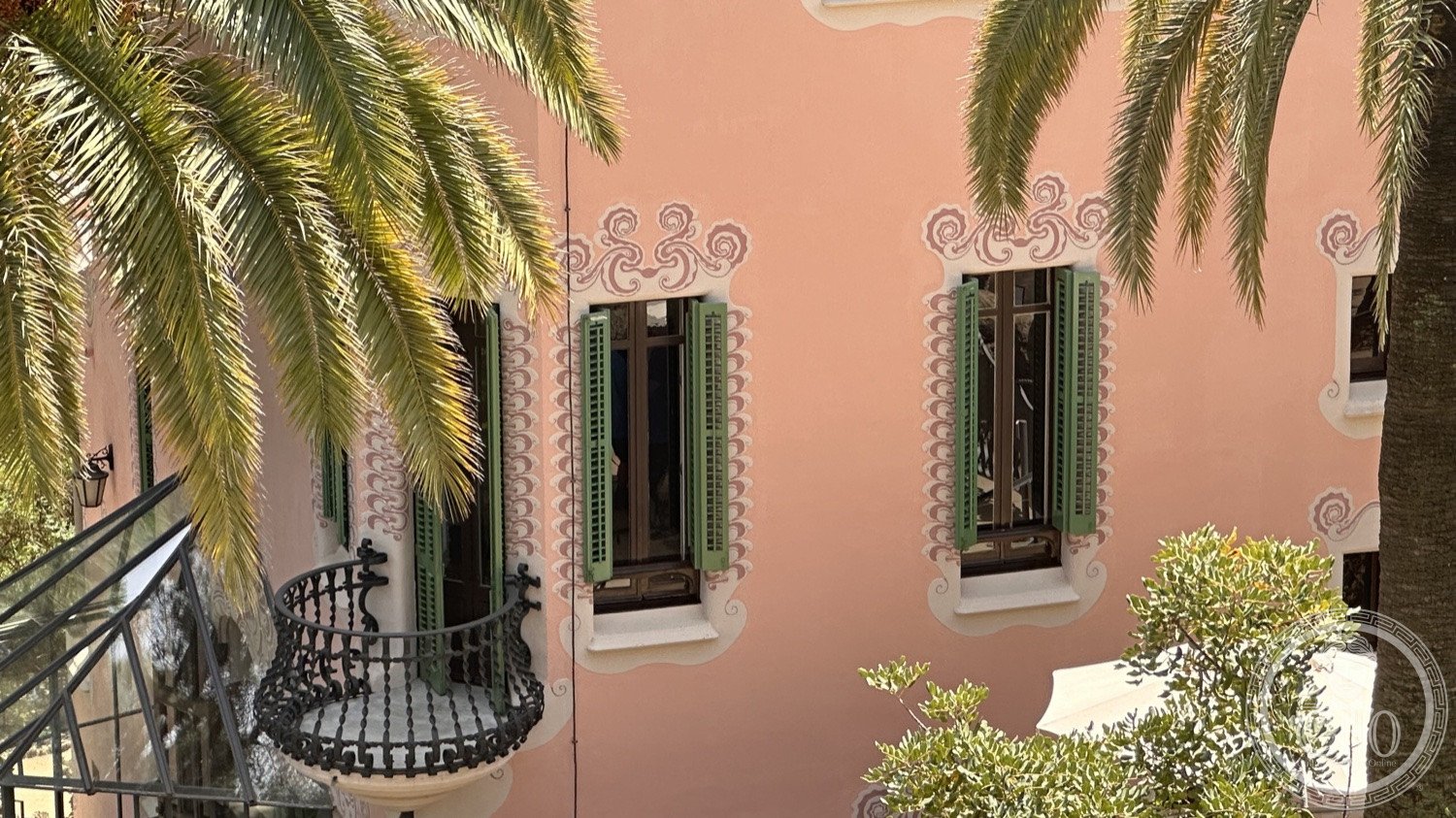 Park Güell — A detail of the pink Gaudí House behind the palms.