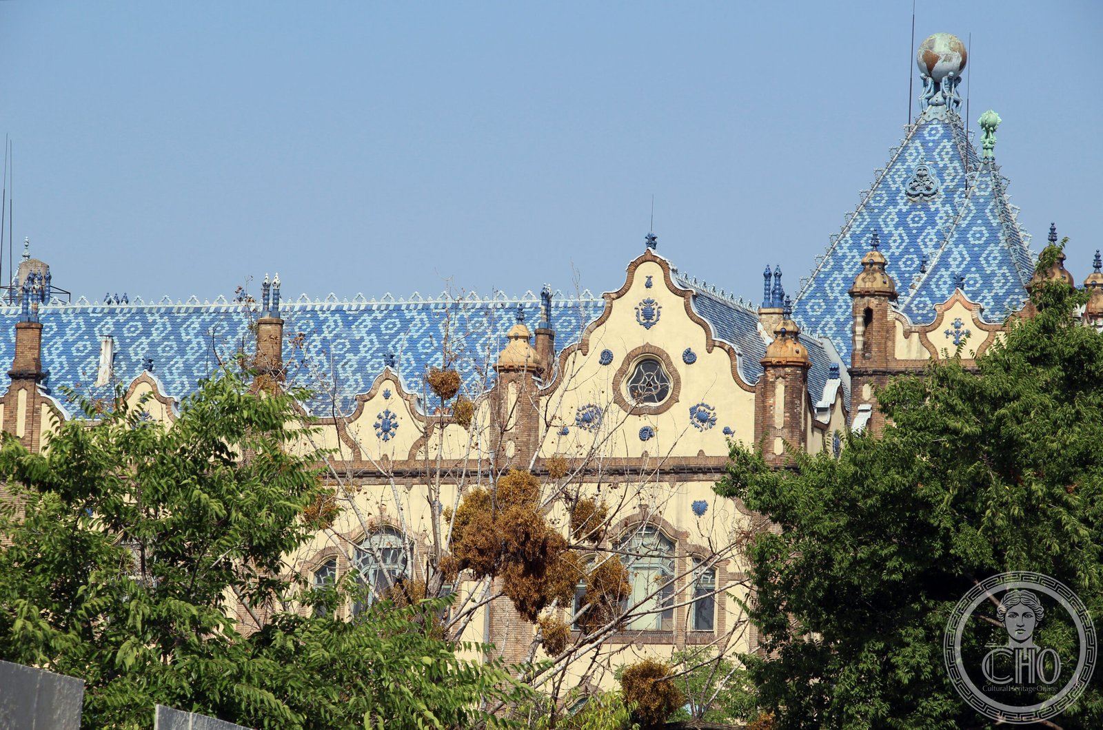 Hungarian Geological Institute facade with Zsolnay ceramic globe-bearers on the roofline, Budapest