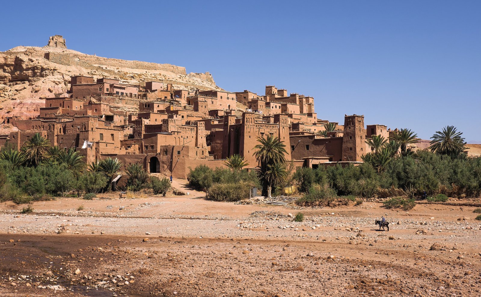Ksar Aït Benhaddou earthen towers rise above the Ounila River valley at dusk