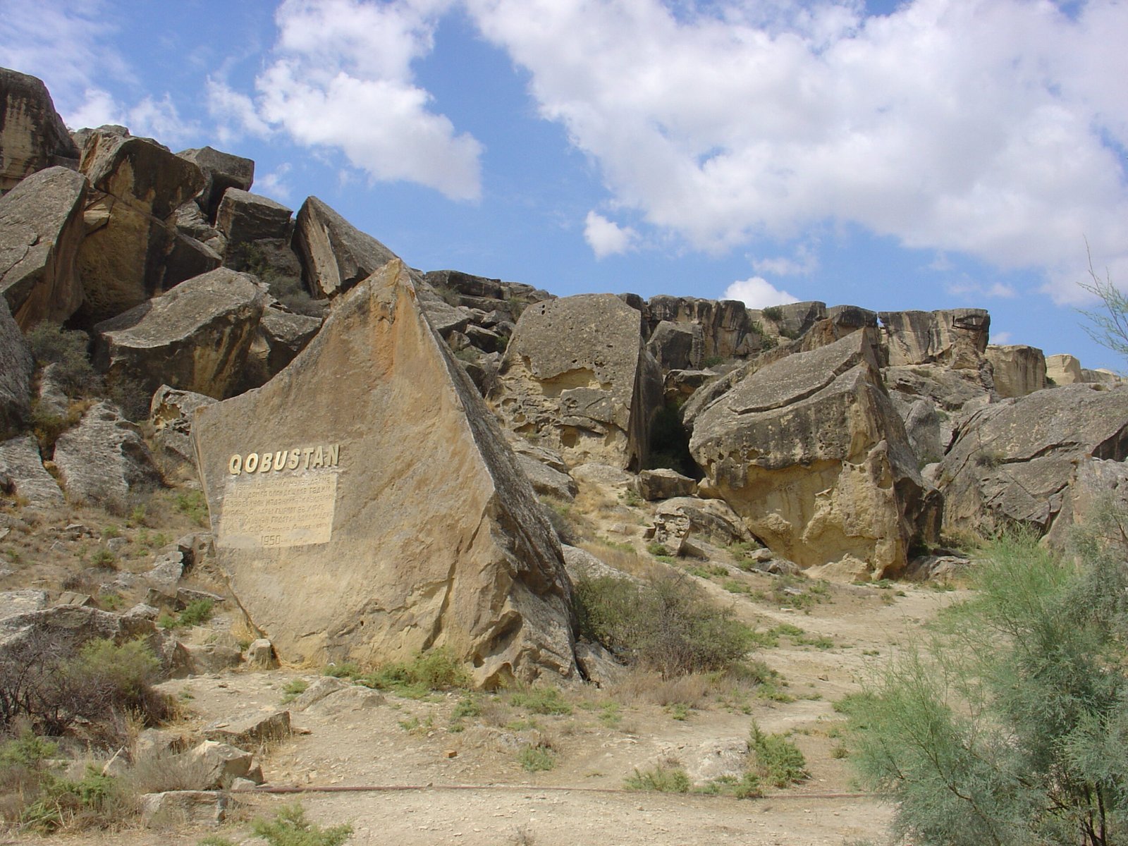 Petroglyphs carved on rock face at Qobustan National Park, Azerbaijan, with Caspian Sea in distance