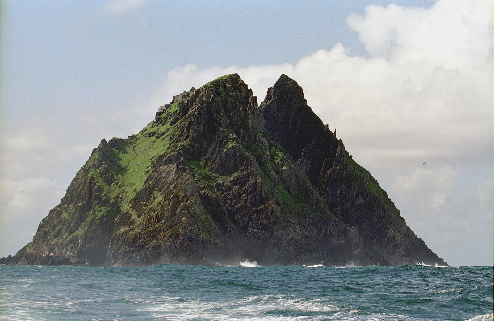 Skellig Michael's rocky pyramid rises from the Atlantic with ancient stone steps visible on the cliff face