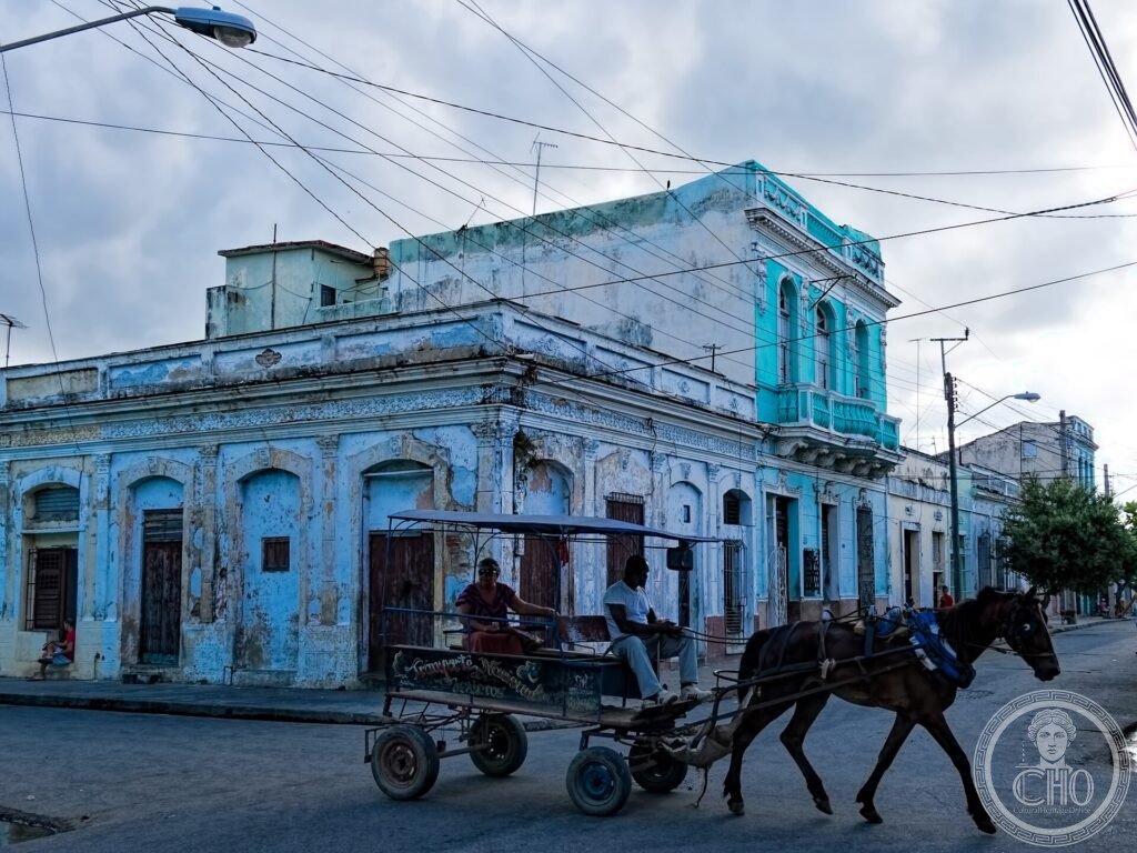 A colourful colonial street corner of Cienfuegos with a horse cart passing by