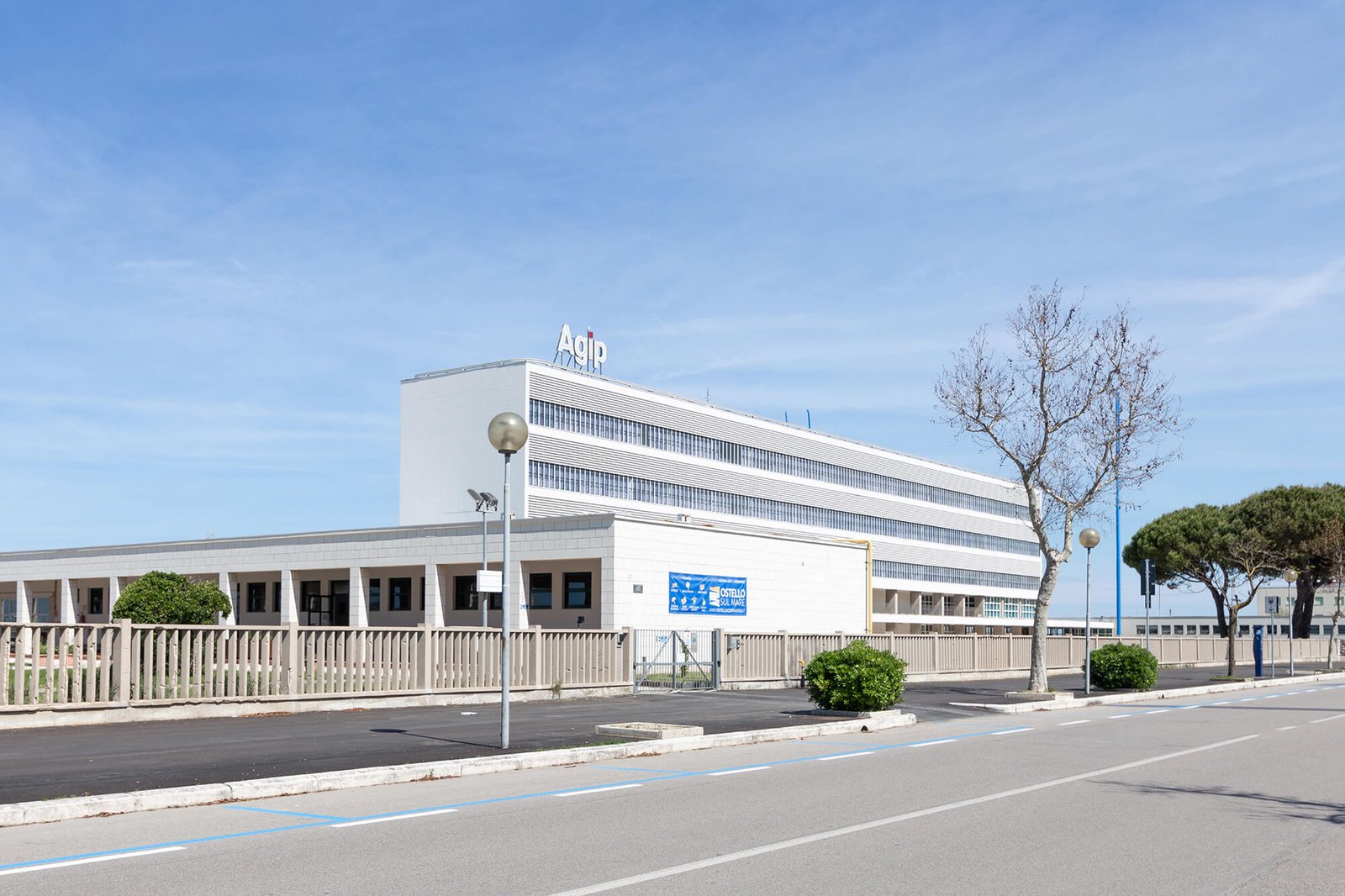 The long four-storey block of the Colonia AGIP in Cesenatico under a blue sky
