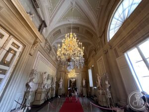 Pitti Palace — neoclassical corridor with chandelier and marble statues, Florence