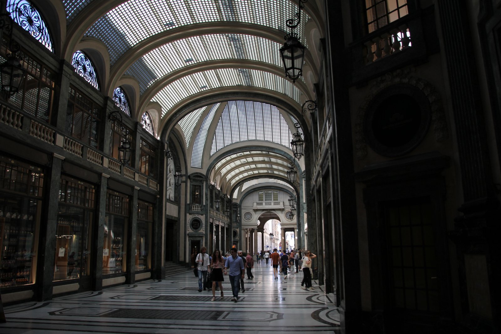 Interior of Galleria San Federico in Turin with its elliptical glass barrel vault and three-arm pedestrian passage.