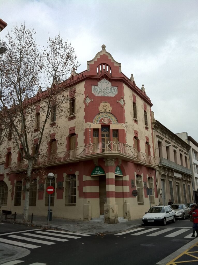 The corner Modernista façade of the Hotel Suís in Sabadell, with brick, sgraffito and mosaic The corner Modernista façade of the Hotel Suís in Sabadell, with brick, sgraffito and mosaic