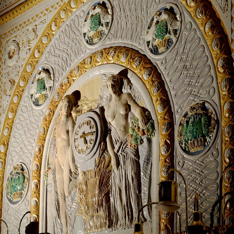 Clock set into a figural ceramic composition, Café Imperial, Prague