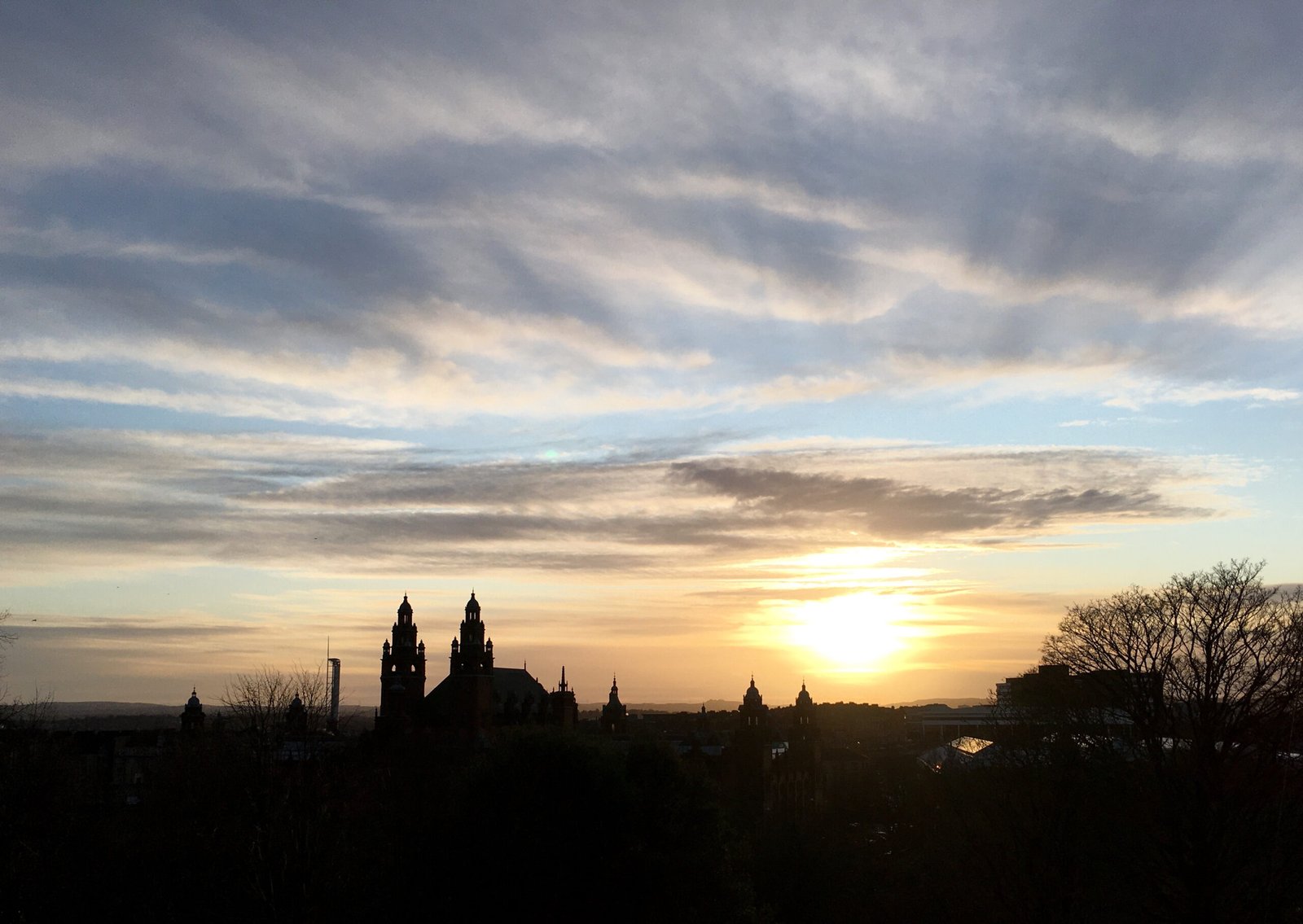 The towers of Kelvingrove in silhouette against a Glasgow sunset