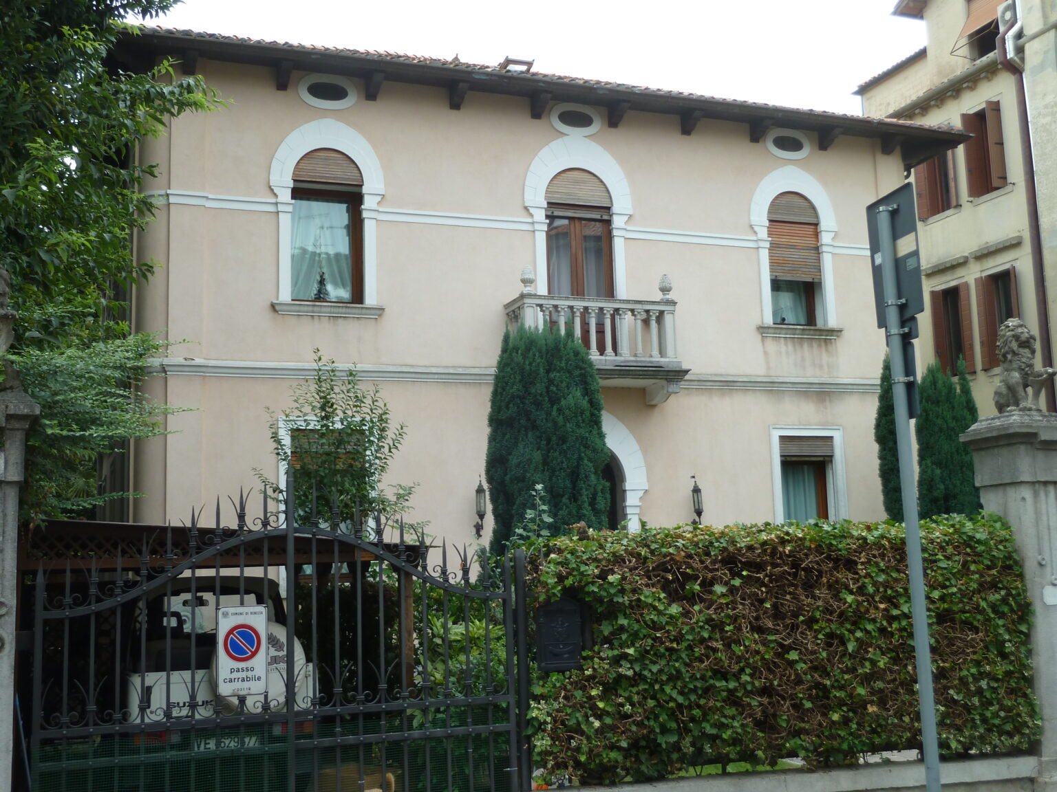 Villino Camuzzoni on the Lido di Venezia, a square villa with a balcony and a gate guarded by two stone lions