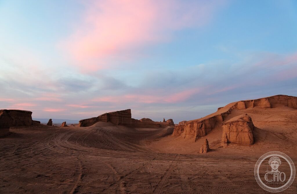 Wind-sculpted ridges (kaluts) of ochre rock and sand at dusk in the Dasht-e Lut desert, Iran