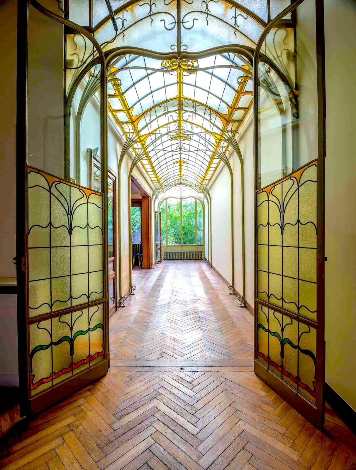 Glazed veranda of Maison Frison, Brussels, with stained-glass doors and herringbone parquet
