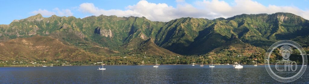 Green mountains rising above Taiohae Bay with sailboats on Nuku Hiva in the Marquesas Islands