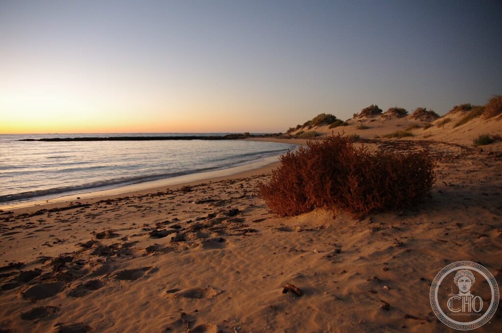 A quiet sandy beach and calm turquoise sea at sunset along the Ningaloo Coast, Western Australia