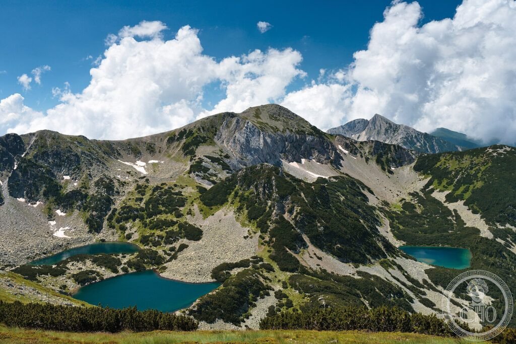 Two deep-blue glacial lakes below rocky peaks and green slopes in Pirin National Park, Bulgaria