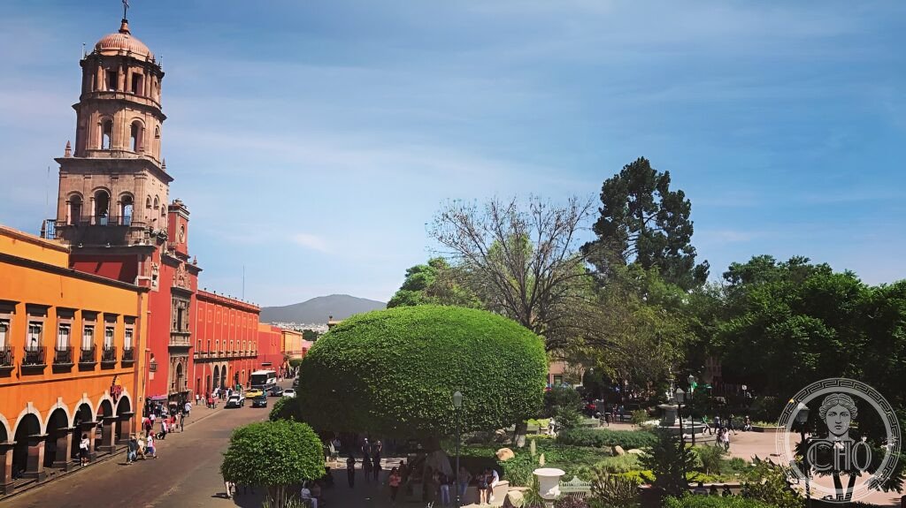 A colonial church tower and colourful arcaded buildings around the Jardín Zenea in Querétaro