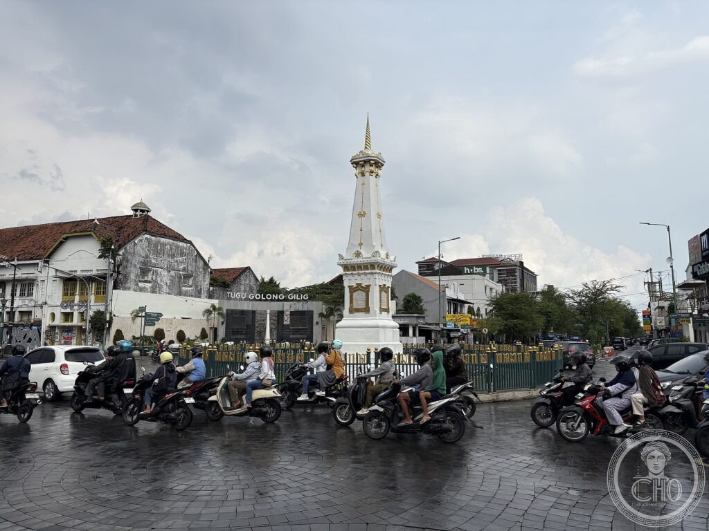 The white Tugu monument at a busy intersection on the cosmological axis of Yogyakarta, Java