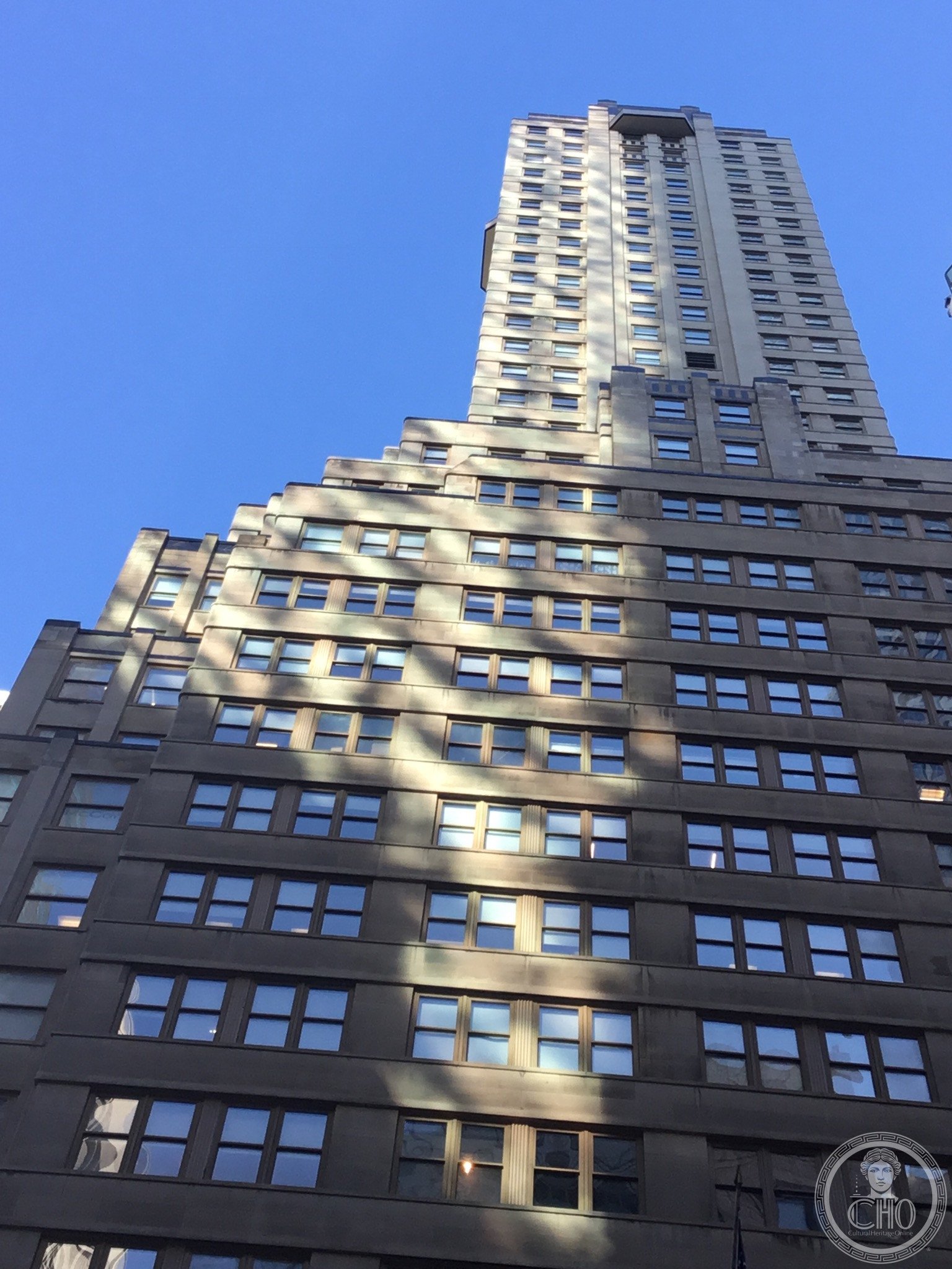 The Fuller Building's black and white Art Deco facade at the corner of 57th Street and Madison Avenue, its figural sculptures flanking the entrance