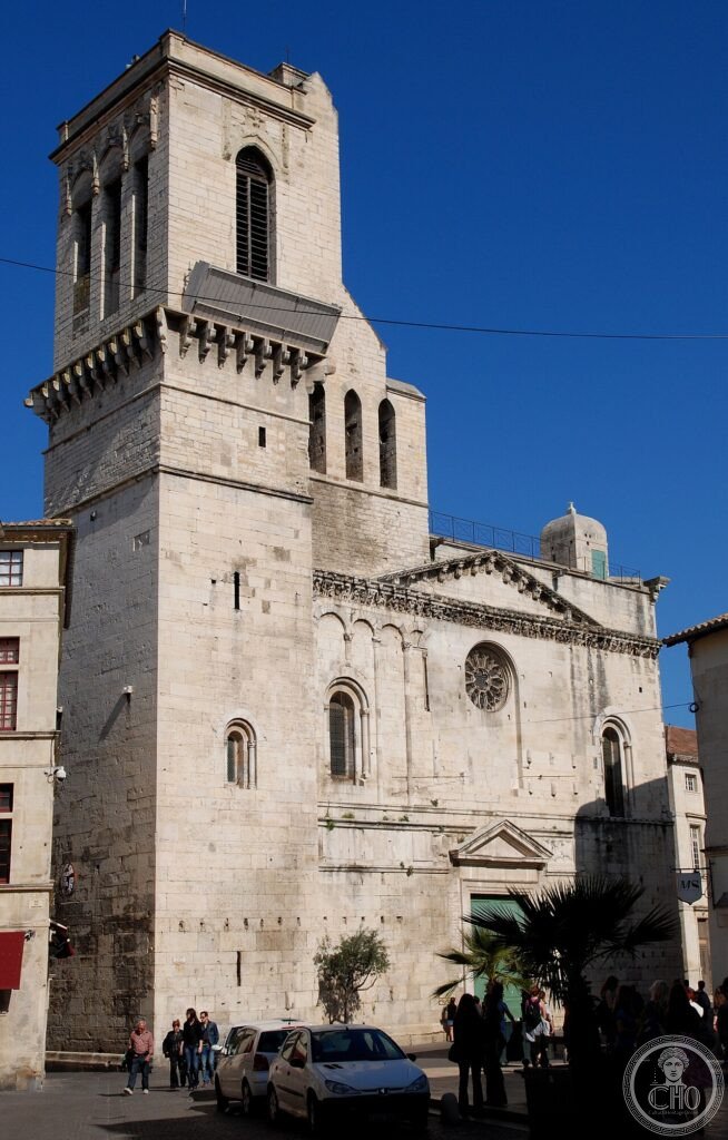 Exterior of Nîmes Cathedral (Cathédrale Notre-Dame-et-Saint-Castor), Occitanie, France, consecrated 1096, with a Romanesque frieze of Old Testament scenes partly rebuilt after 17th-century religious war damage