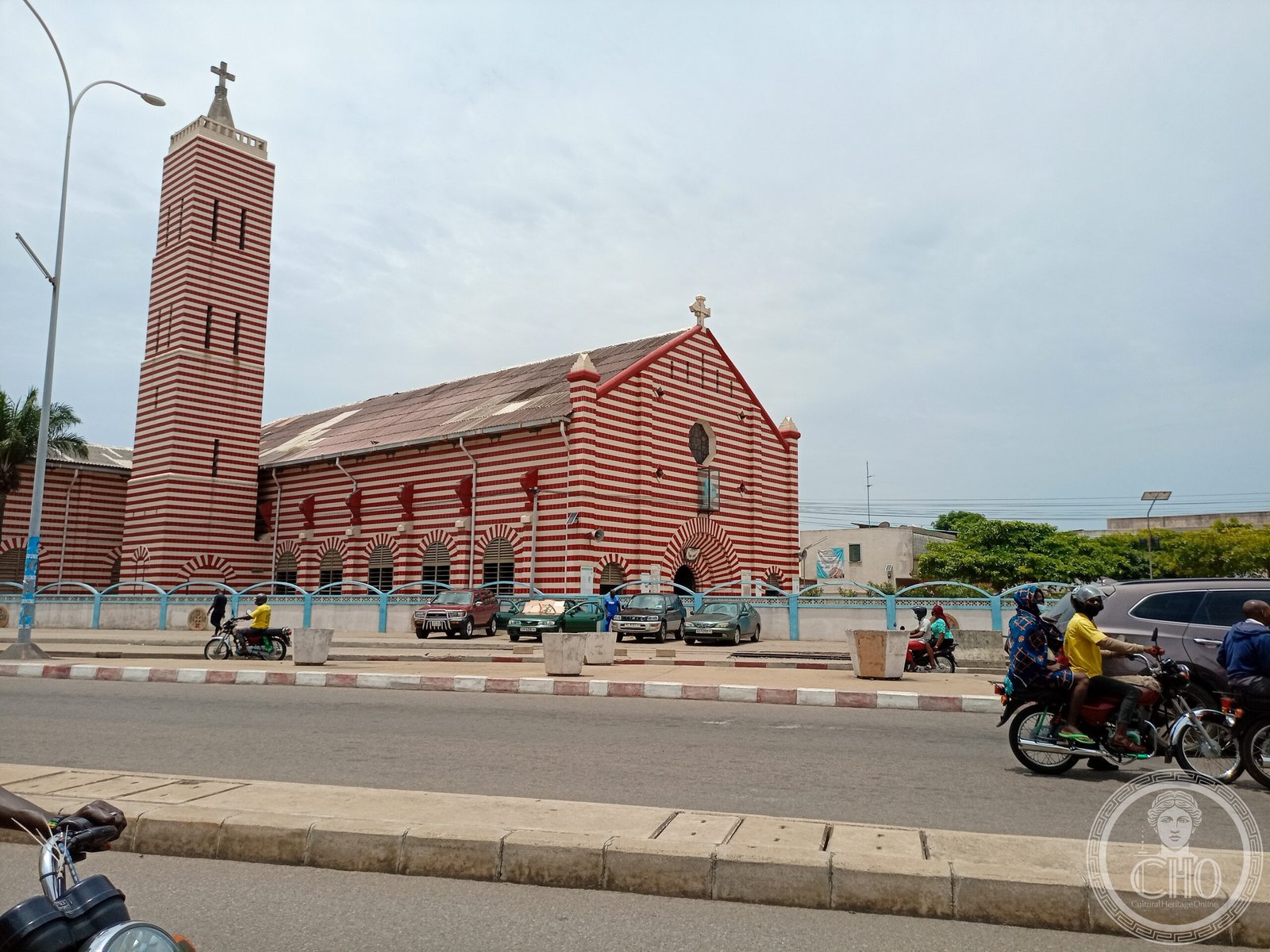 Cotonou Cathedral, Benin, a striking facade of alternating burgundy and white ceramic tile stripes with a rose window and bell tower
