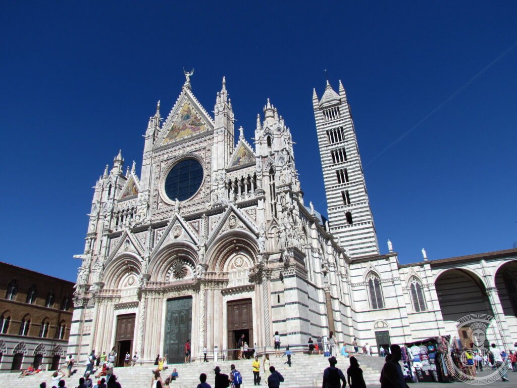 Facciata gotica in marmo bianco e verde del Duomo di Siena, Toscana, con il campanile a bande