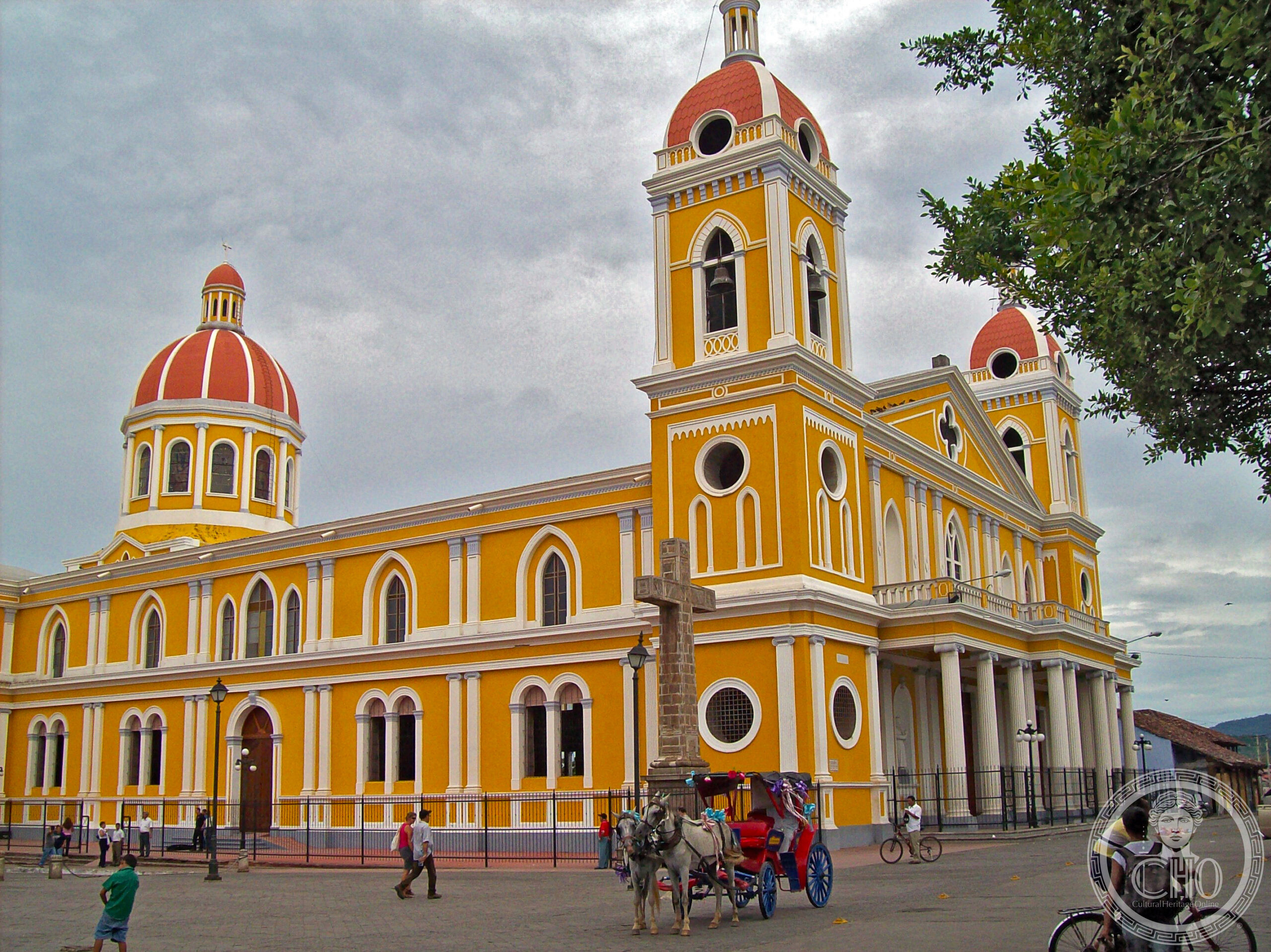 Cathedral of Granada, Nicaragua, a yellow and white neoclassical facade with twin bell towers and red-tiled domes, on Parque Central