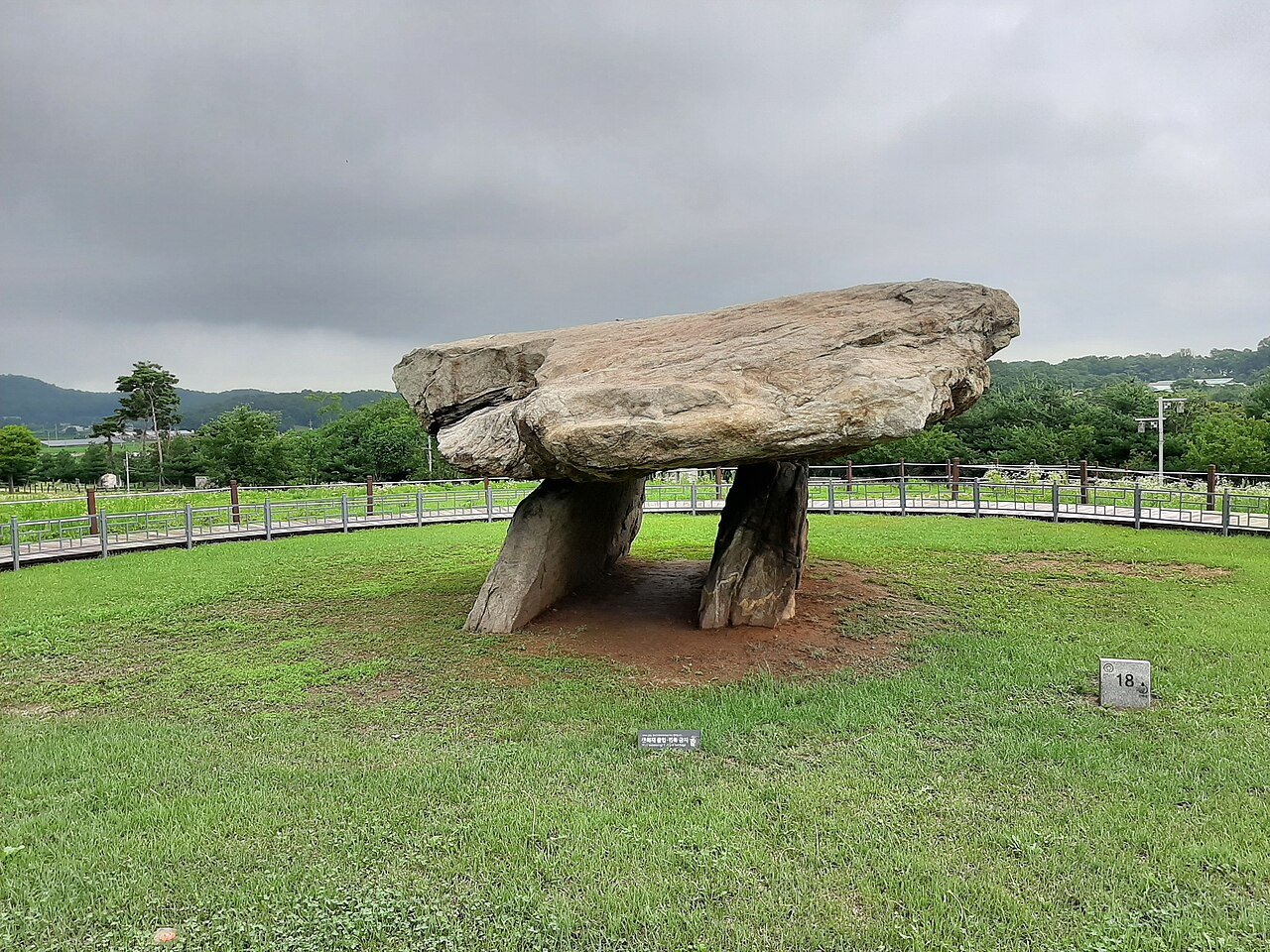 Table-type dolmen capstone on Ganghwa Island, South Korea, a massive flat stone supported by two upright stones in a rice paddy landscape