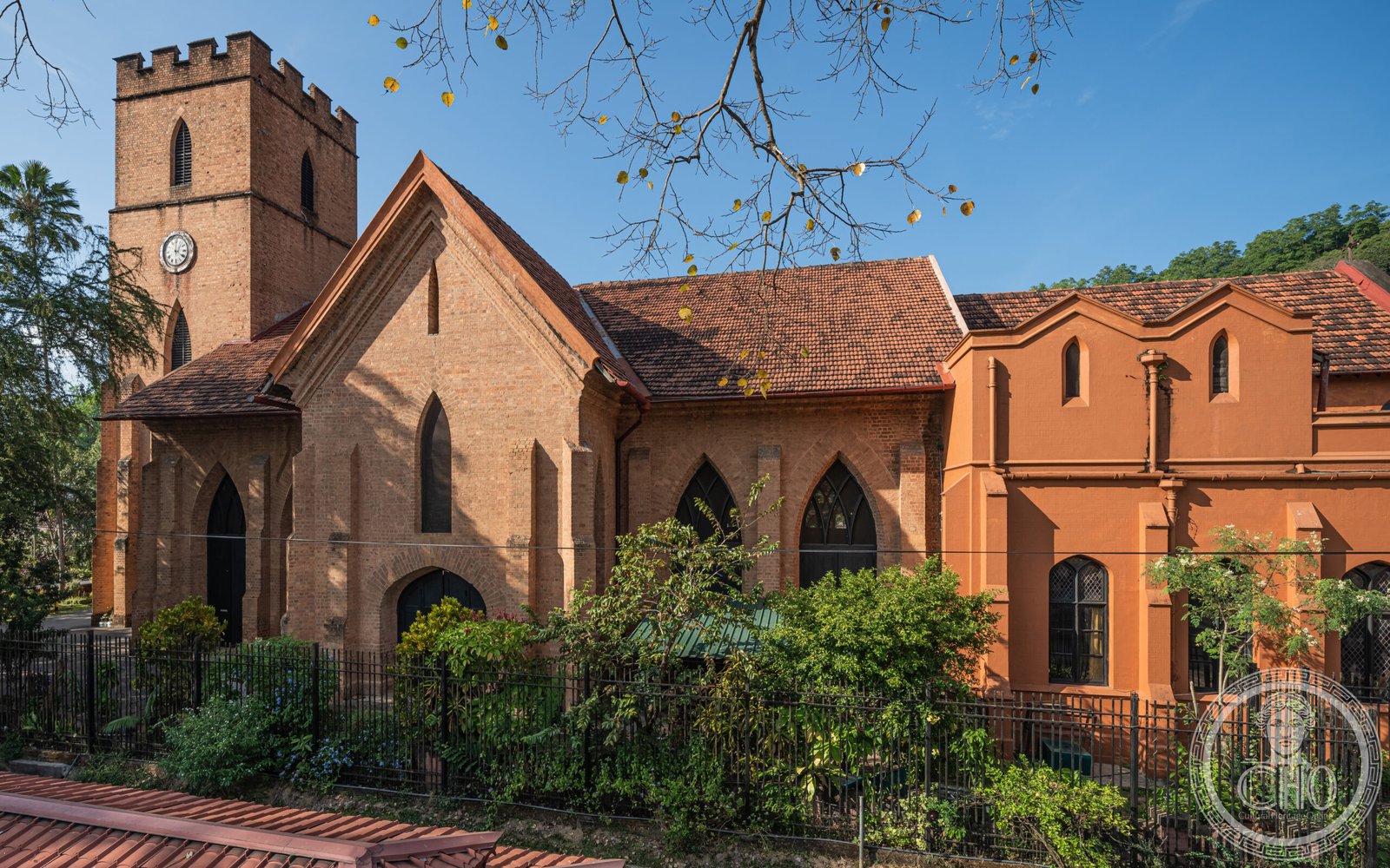 St. Paul's Church in Kandy, Sri Lanka, a red-brick Neo-Gothic church with a castellated tower, standing beside the Temple of the Sacred Tooth Relic