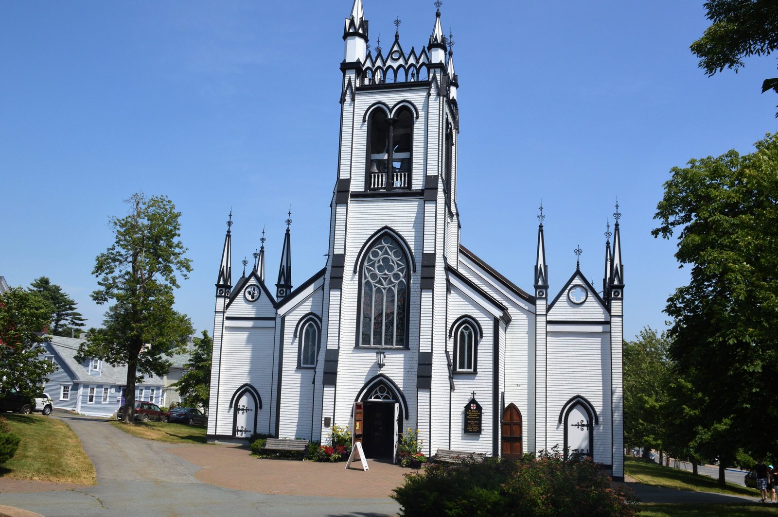 St. John's Anglican Church in Lunenburg, a white-and-black wooden Carpenter Gothic church with a crenellated belfry tower and corner pinnacles