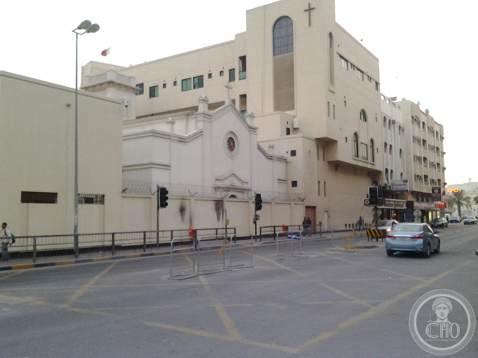 Sacred Heart Church in Manama, Bahrain, a gabled facade with a circular rose window, a small cross on the gable, and an adjoining tower with a large arched window and cross